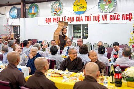 Quý Thầy ngồi bàn trước biểu ngữ Đạo Phật Là Đạo Của Trí Tuệ Và Giác Ngộ