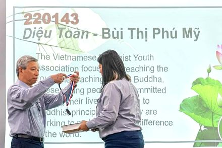 Trao huy chương cho một huynh trưởng có bài luận khóa xuất sắc, màn hình chiếu tên bài