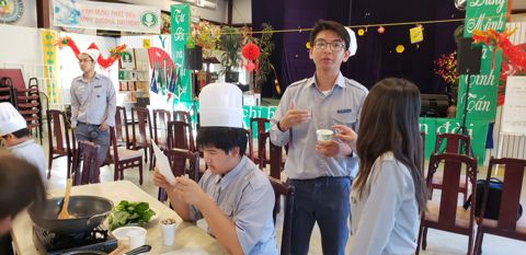 Anh Huynh Trưởng đứng giữa các em, dặn dò trước khi vào bếp