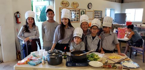 Đội Chef Phú Quý chụp chung sau bếp: hai anh chị Ngành Thiếu, ba em Oanh Vũ, nồi và chảo trước mặt